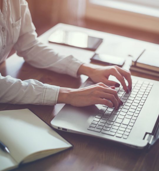 Woman working in home office hand on keyboard close up.